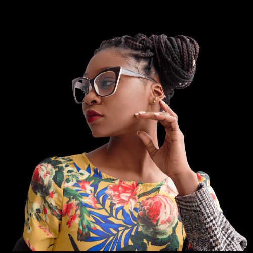Stylish woman wearing glasses and a colorful floral top, looking to the side confidently against a black background